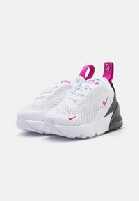 Valged silmajalatsid roosade aktsentidega, millel on tekstuuriga pealne, must konts ja tõmmatav riba. Igal küljel on roosa Nike logo.