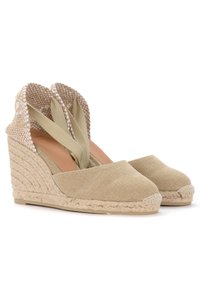 Zoccoli espadrilles beige con suola in corda di juta, tomaia in tessuto e retro testurizzato. Presentano ampie fasce in tessuto disposte a incrocio.