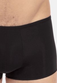 Zwarte boxershorts met een gladde textuur en elastische tailleband, met een eenvoudig ontwerp en zonder zichtbare patronen of accenten.