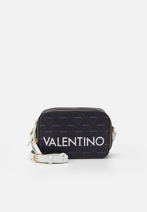 Compacte rechthoekige donkerblauwe Valentino schoudertas met wit logo, witte verstelbare schouderband en gouden ritsdetails.