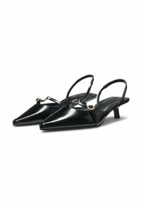 Black patent leather slingback heels with pointed toes, thin straps featuring circular gold accents, and a small block heel.