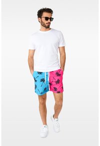 Svøm shorts med split-design: blå på den ene side og pink på den anden. Begge sider har sorte palmetræsmønstre. Hvid snøre lukning.