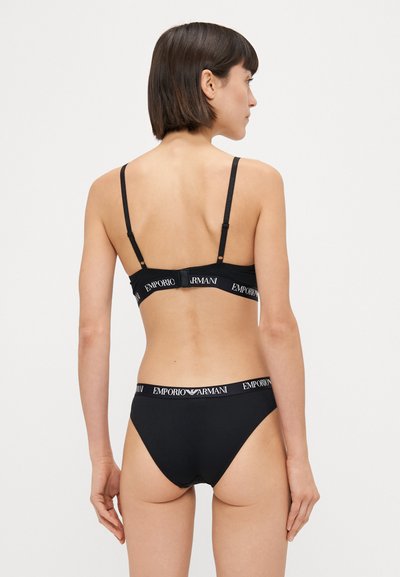 Set de lenjerie intimă neagră, prezentând un sutien cu bretele ajustabile și închidere cu cârlig, însoțit de un slip asortat. Accente cu bandă logo pe ambele piese.