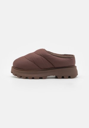 Brune quiltet slip-on sko med rund tå, polstret innside og en tykk, robust gummisåle med dype spor for godt grep.