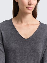 Suéter de punto gris con diseño de cuello en V y una textura suave. La tela se ve lisa, destacando una silueta ajustada y cómoda.