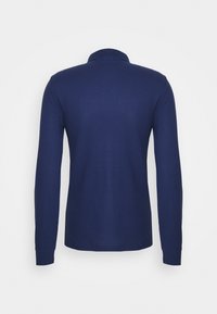 Navy blue long-sleeve polo shirt shown from the back with a ribbed collar and cuffs on a white background.