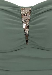 Vihreä olkaimeton toppi, jossa on kerätty muotoilu ja keskeinen koristelu metallisequins- ja kirkashelmiä.