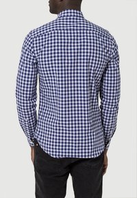 Marinblå och vit rutmönstrad skjorta med knappar och långa ärmar, med en lätt rundad fåll och strukturerad krage, tillverkad av ett lätt material.