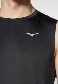 Černé bezrukávové sportovní tričko s hladkou texturou, které má bílé logo na hrudi a kulatý výstřih.