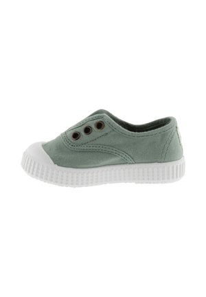 Scarpa slip-on in tela verde chiaro con suola e punta in gomma bianca, caratterizzata da tre occhielli in metallo sul lato.