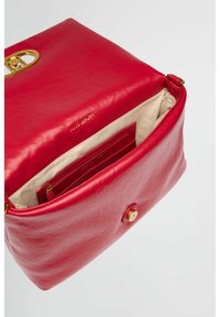 Sac en cuir rouge avec une texture lisse et moelleuse, des accents en métal doré, une fermeture à rabat et un intérieur beige avec des poches de rangement.