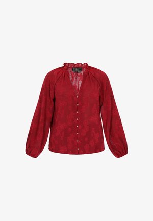 Czerwona bluzka z kwiatowym wzorem z koronki, długimi bufiastymi rękawami i zapinana na guziki z przodu; posiada falbaniaste wykończenie przy dekolcie oraz miękki, fakturowany materiał.