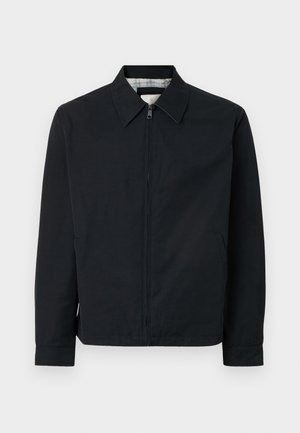 Chaqueta negra con cremallera frontal, cuello puntiagudo, bolsillos laterales y un forro de cuadros en contraste. Presenta mangas largas y un corte recto.