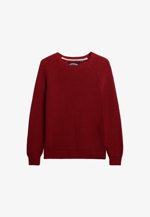 Czerwona sweter robiony na drutach z okrągłym dekoltem, długimi rękawami raglanowymi i ściągaczem na dole. Tekstura charakteryzuje się średnim wzorem dzianiny. Metka widoczna wewnątrz dekoltu.