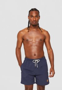 Navy swim shorts with elastic waistband, white drawstring, and side pockets. Made of lightweight fabric with a smooth texture.