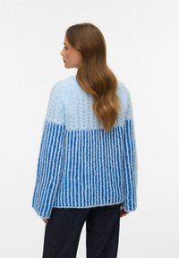 Hele sinine kudumissärk, millel on tekstureeritud mustriga tumedama sinise triibumustriga. Pika varruka, lõdva istuvuse ja ümara kaelusega.