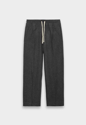 Mørkegrå bukser laget av teksturert stoff; har et elastisk liv med en kremfarget snor og to sidelommer. Rett ben-design.