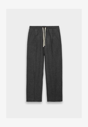 Dark gray pants made of textured fabric; features an elastic waistband with a cream drawstring and two side pockets. Straight-leg design.