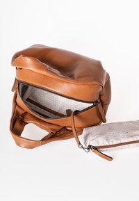 Bruine leren tas met gestructureerd oppervlak, ritsafsluiting en dubbele handvatten; inclusief een kleine, patroonrijke ritstas in lichte kleur.