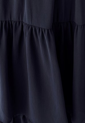 Dunkelblaues, gestuftes Kleid aus strukturiertem Stoff. Verfügt über eine geraffte Detailierung an der Taille und eine fließende Silhouette.