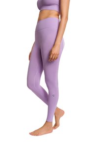 Lavendel hochtaillierte Leggings mit glatter Textur, ausgestattet mit einer Seitennaht und einem kleinen Logo in der Nähe des Knöchels. Ein tailliertes Design für aktive Kleidung.