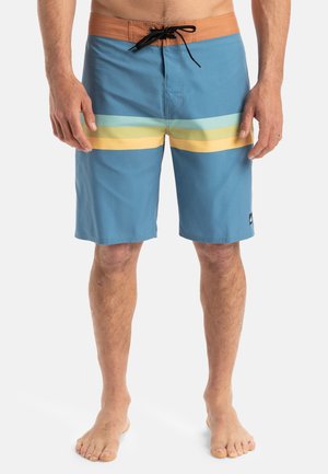 Blue men's swim trunks with yellow and green horizontal stripes, featuring a brown waistband, adjustable drawstring, and side pocket.