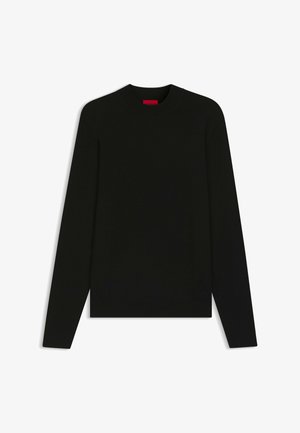 Pull noir à manches longues avec un col rond, fabriqué en tissu lisse. Il présente un ourlet et des poignets côtelés, avec une étiquette de marque rouge à l'intérieur.