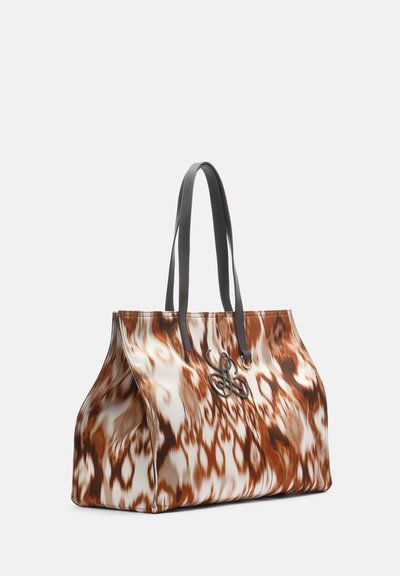 Large tote bag with brown and white abstract pattern, black handles, and a decorative black metal emblem on front.