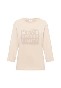 Beżowy pulower z rękawami do łokcia, z teksturowanym wzorem graficznym z napisem "PRZEKRACZAJ GRANICE" i małymi dziurkami.