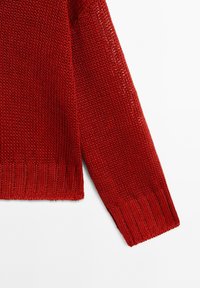 Maglione rosso lavorato a maglia con trama allentata, polsini e orlo a costine. Presenta una vestibilità rilassata e una superficie testurizzata.