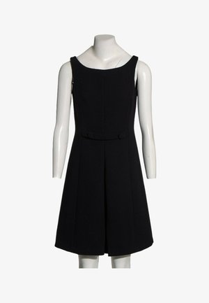 Robe noire sans manches longueur genou avec taille cintrée et légère évasée, présentée sur un mannequin blanc sur fond blanc.