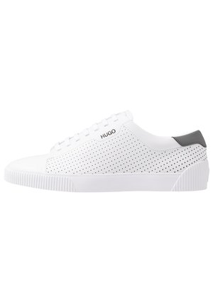 Hvid lavtop sneakers med perforerede sider, sort hæltab, hvid gummisål og "HUGO" logo nær snørebånd.