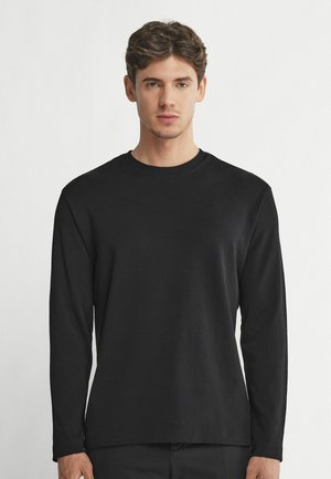 Czarny longsleeve z długim rękawem, uszyty z miękkiej tkaniny, z okrągłym dekoltem. Minimalistyczny design bez widocznych logo i wzorów. Prosty krój.