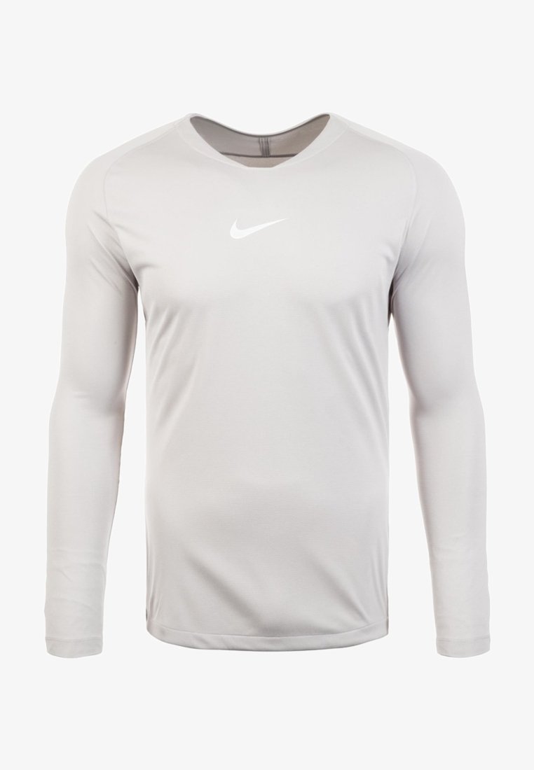 Maglia Nike a maniche lunghe grigia chiara con scollo rotondo, texture liscia e piccolo logo bianco sul petto. Leggera, vestibilità atletica.