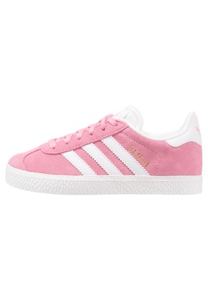 Lyserøde ruskindssneakers med hvid sål, hvide Adidas tre striber, hvid hælkappe og "GAZELLE" tekst i guld på siden.