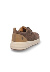 Zapatilla de ante marrón con un talón de lona beige, suela de goma clara y cordones en la parte frontal. Presenta un logotipo discreto en el talón.