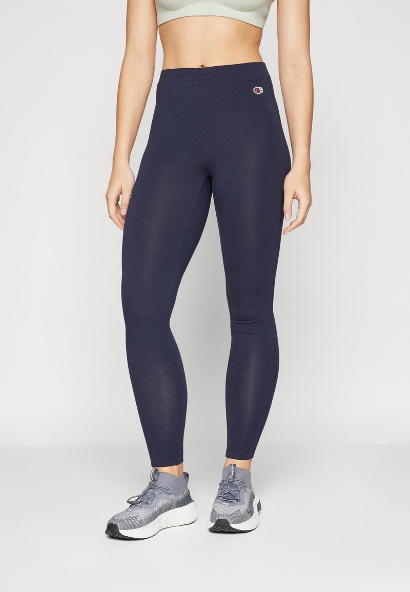 Leggings blu navy con vita alta, realizzati in un materiale elastico, dotati di un piccolo logo sull'anca e una texture liscia e uniforme.