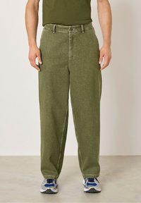 Zelené široké kalhoty vyrobené z texturované tkaniny, s klasickým zapínáním na knoflík, dvěma bočními kapsami a mírně zúženými lemy.