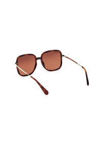 Gafas de sol en carey marrón con montura cuadrada, lentes marrones degradados y detalles dorados en las patillas. Diseño clásico y elegante.