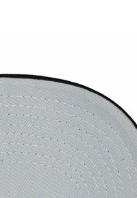 Grau verfolgendes Stoffmütze mit einer strukturierten Oberfläche, die konzentrische Nähmuster aufweist und einen schwarzen Besatz an der Kante hat.