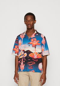 Cămașă cu mânecă scurtă într-un model floral colorat, cu nuanțe strălucitoare de roz, roșu și albastru, având un guler cu nasturi și o croială lejeră.