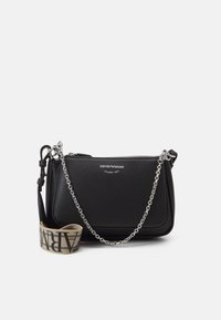 Černá kožená crossbody taška s texturovaným povrchem, stříbrným řetízkovým popruhem a látkovou rukojetí s výrazným písmem. Zapínání na zip.