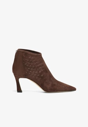 Bruine suède enkellaars met geperforeerd ontwerp, puntige neus en een hak van 5 cm. Zijritssluiting en een gladde textuur accentueren de silhouet.