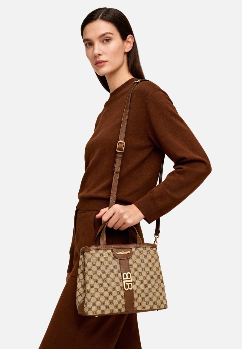 Borsa beige con motivo, dettagli marrone scuro e logo oro. Dotata di manico superiore e tracolla removibile. Tessuto strutturato.