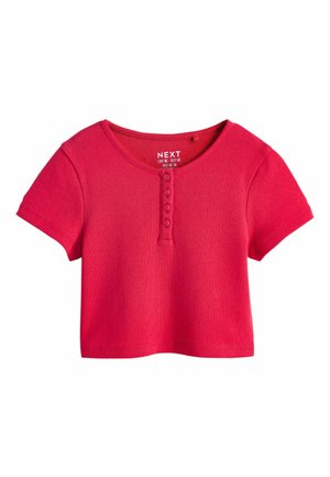 Krótki różowy sweter damski z krótkim rękawem, okrągłym dekoltem i czterema guzikami na środku przodu.