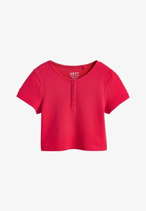 Top scurt din tricot, de culoare roz aprins, cu mâneci scurte, decolteu rotund și patru nasturi în partea din față, în centru.