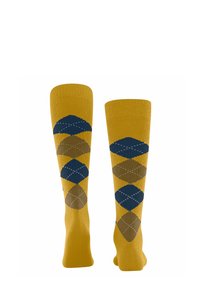 Calze al ginocchio con una base gialla e motivi a rombi blu e marroni, accentuate da cuciture bianche.
