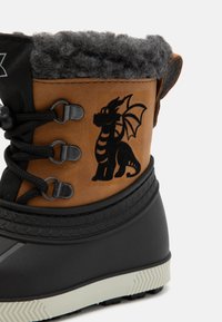 Brauner und schwarzer Winterstiefel mit einem plüschigen grauen Bündchen, ausgestattet mit einem schwarzen Drachenmuster, strukturierter Gummisohle und Metall-Schnürhaken.