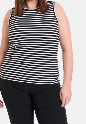 Top sin mangas a rayas blancas y negras en textura acanalada, combinado con pantalones negros. El top presenta un escote redondo y una silueta ajustada.