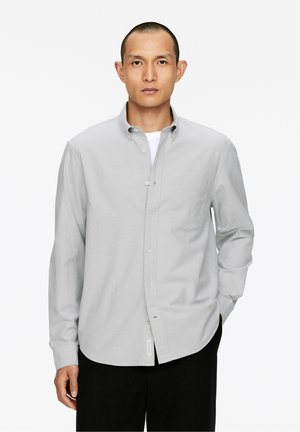 Hellegrau Langarm-Hemd mit Knöpfen, aus Baumwolle, mit einer Brusttasche, klassischem Kragen, geradem Saum, kombiniert mit schwarzen Hosen.